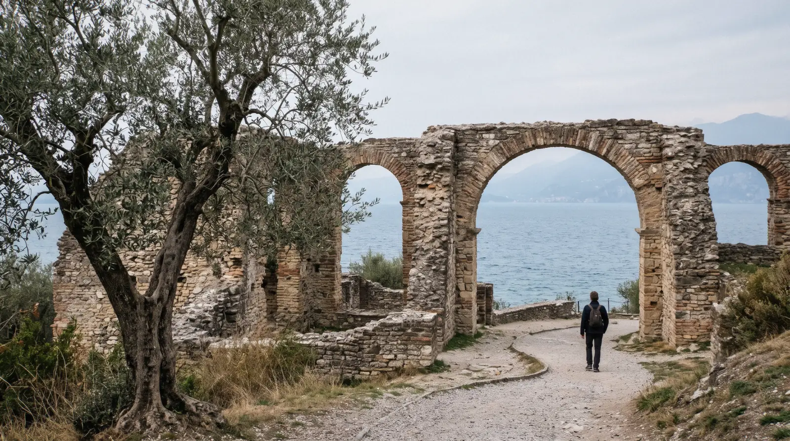 The Roman arches of the Grotte di Catullo above the lake at the tip of Sirmione, Lake Garda, Italy