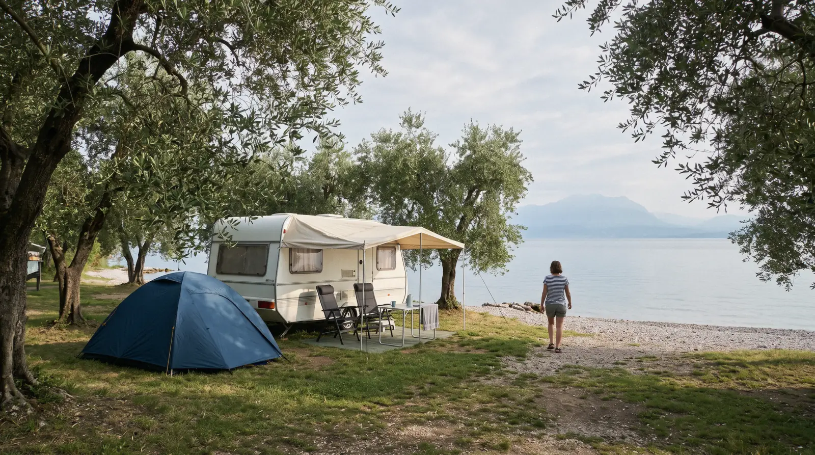 A tent and caravan under olive trees by the water near Lazise, Lake Garda camping, Italy