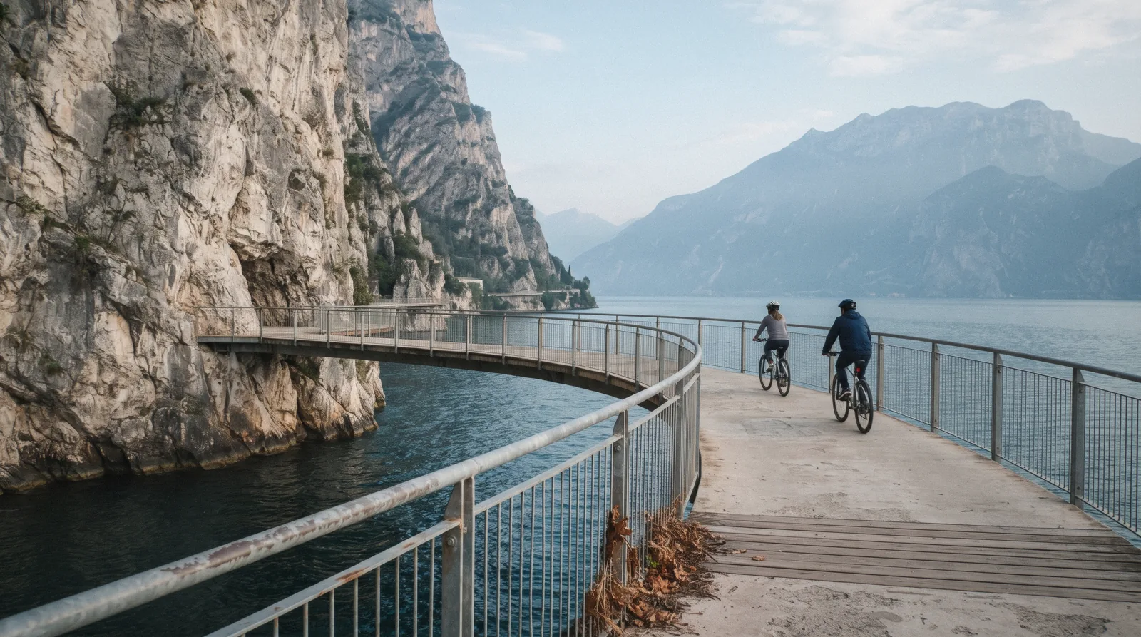 Cyclists on the suspended walkway above Lake Garda north of Limone, Italy