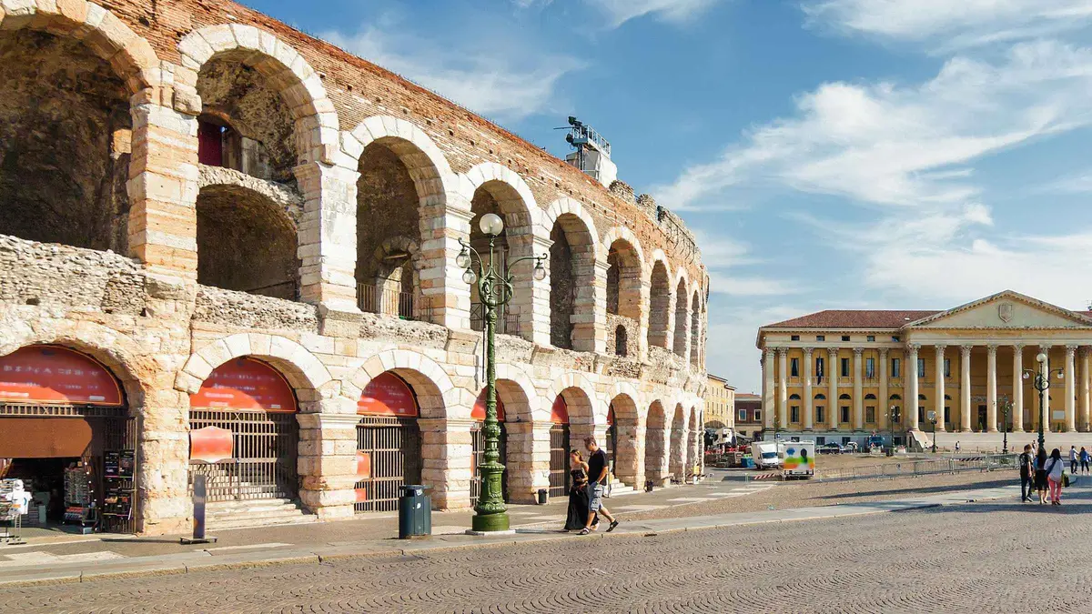 The Roman Arena of Verona with its stacked stone arches and the Piazza Bra pavement in front