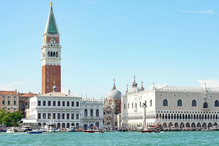 A Venice canal with gondolas and palazzi, the destination of a full-day tour from Lake Garda