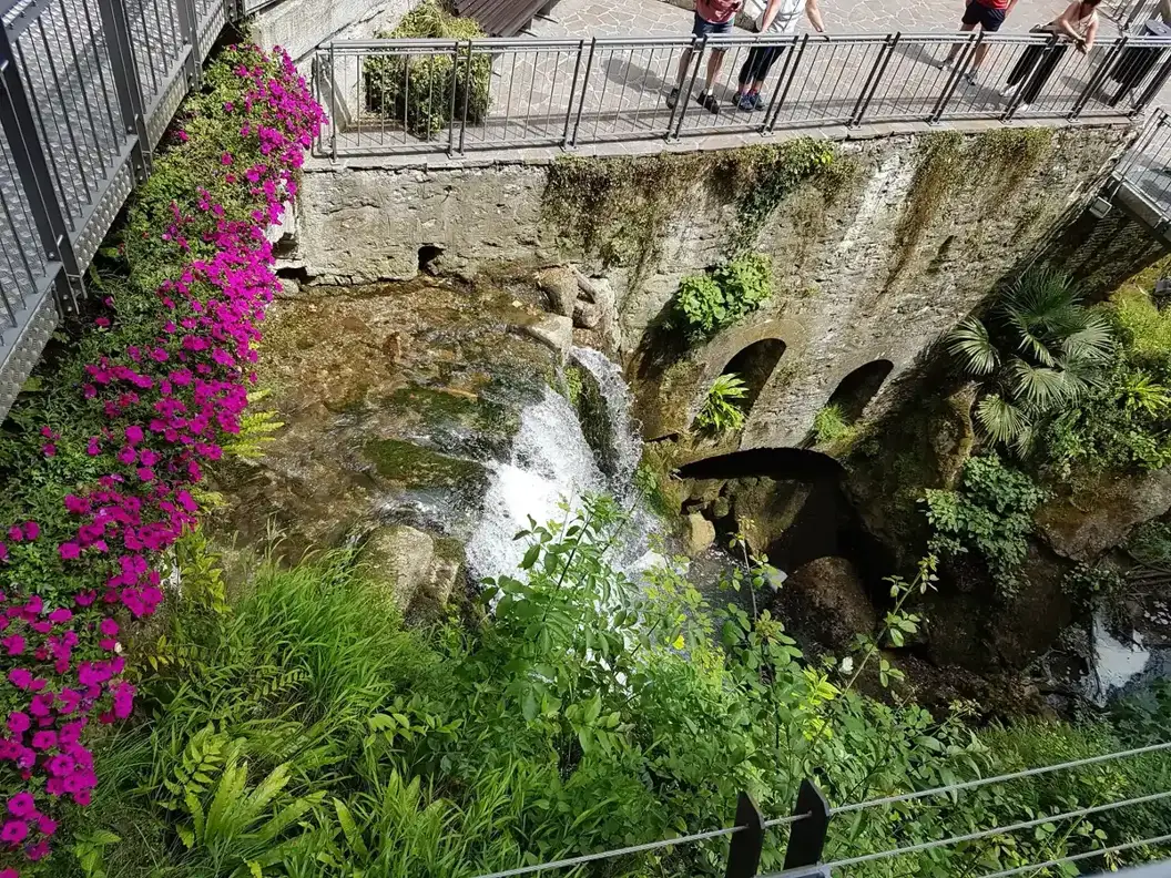 The Varone stream leaving the cave below the walkways of the Parco Grotta Cascata Varone, Tenno, Lake Garda, Italy