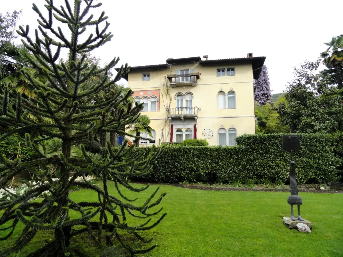The villa and lawn of the Heller botanical garden in Gardone Riviera, Lake Garda, Italy, with a monkey puzzle tree and a sculpture