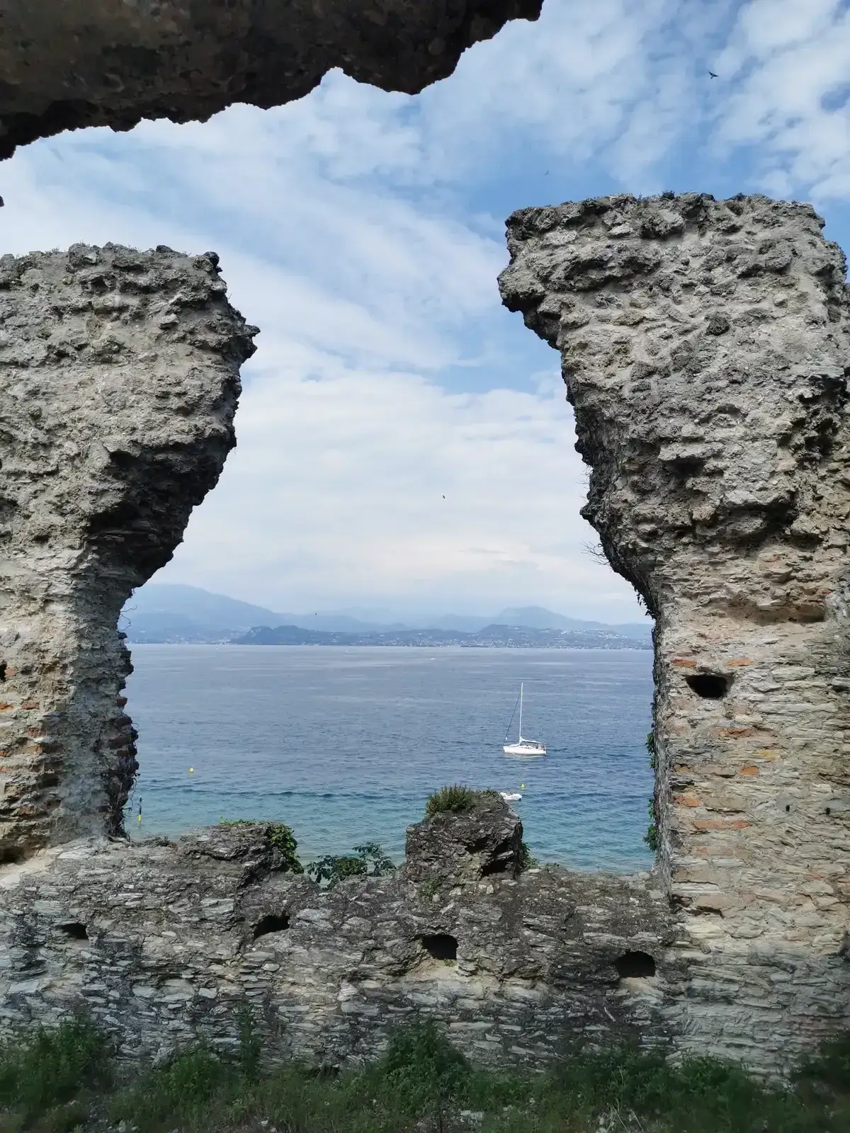 Two ruined Roman piers framing the open lake at the northern tip of the Grotte di Catullo, Sirmione, Lake Garda, Italy