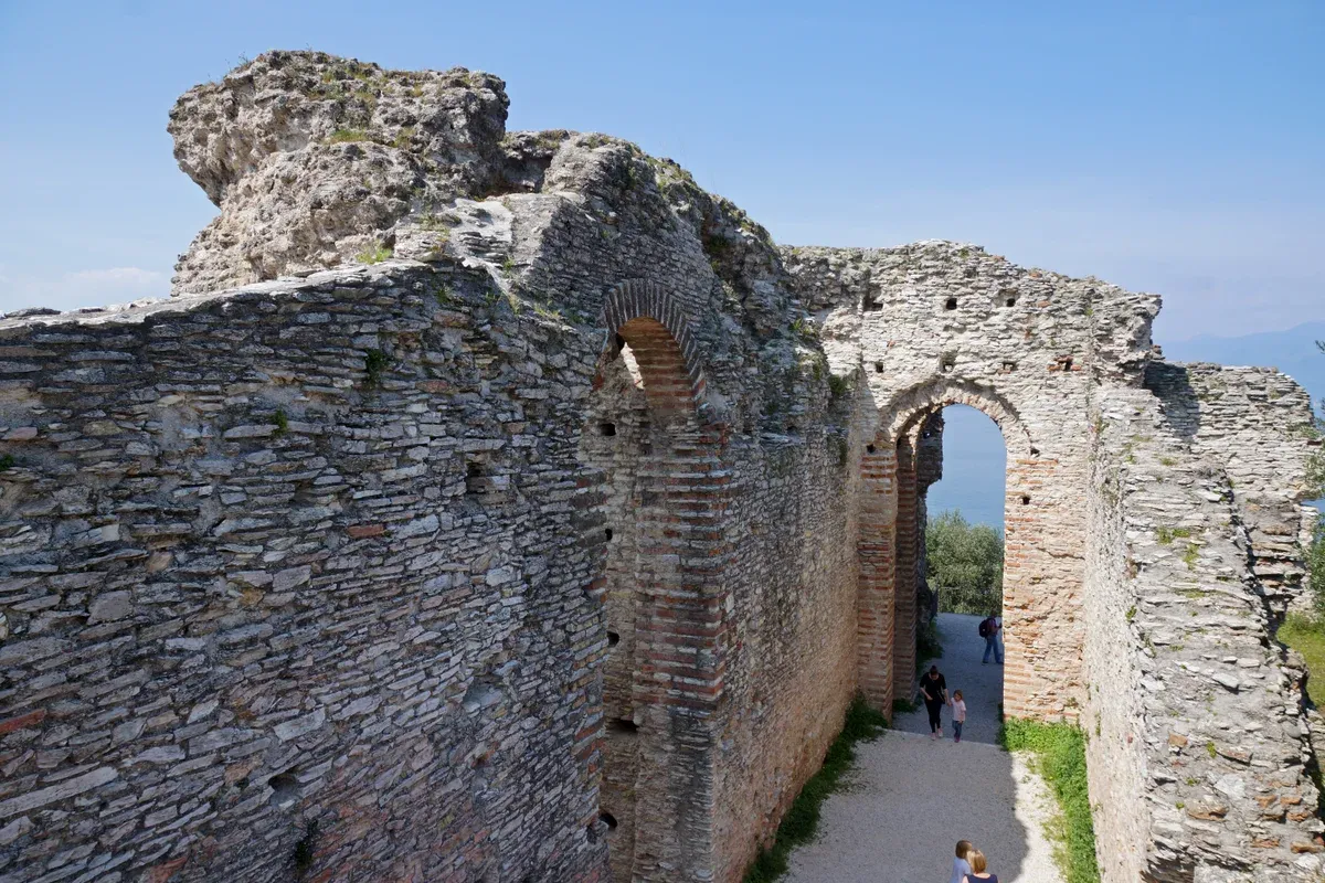 Roman stone and brick walls with an arched passage at the Grotte di Catullo in Sirmione, Lake Garda, Italy