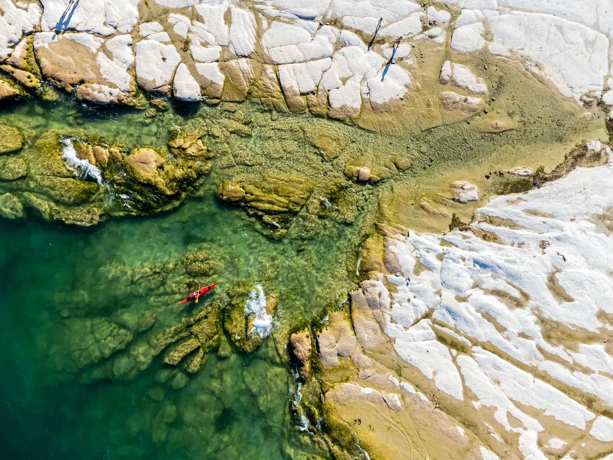 Aerial view of the white rock slabs and clear water at Jamaica Beach, Sirmione, Lake Garda, Italy