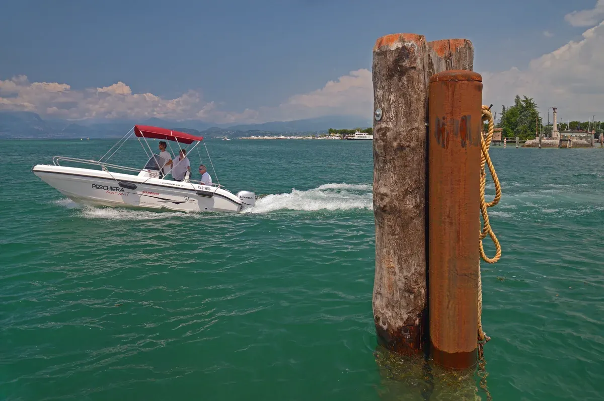 A small motorboat leaving a jetty on Lake Garda, Italy
