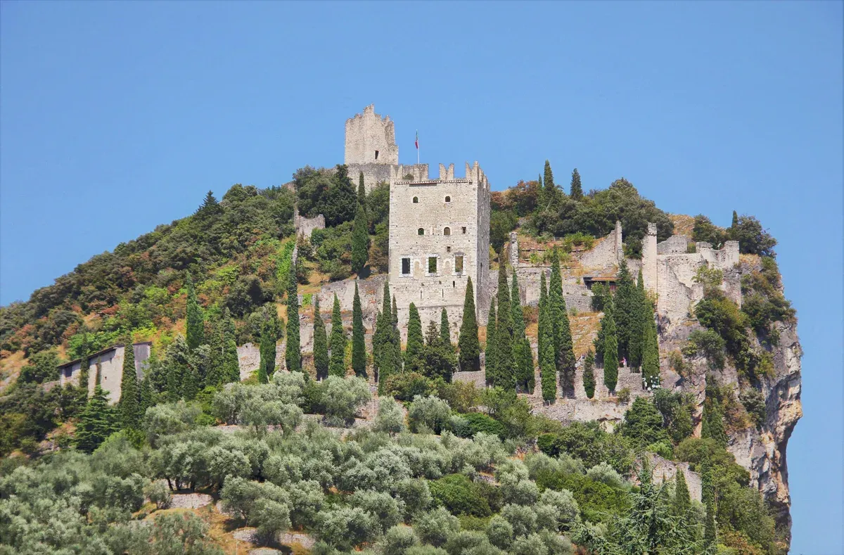 Castello di Arco on its rock above olive groves and cypresses near Lake Garda, Italy