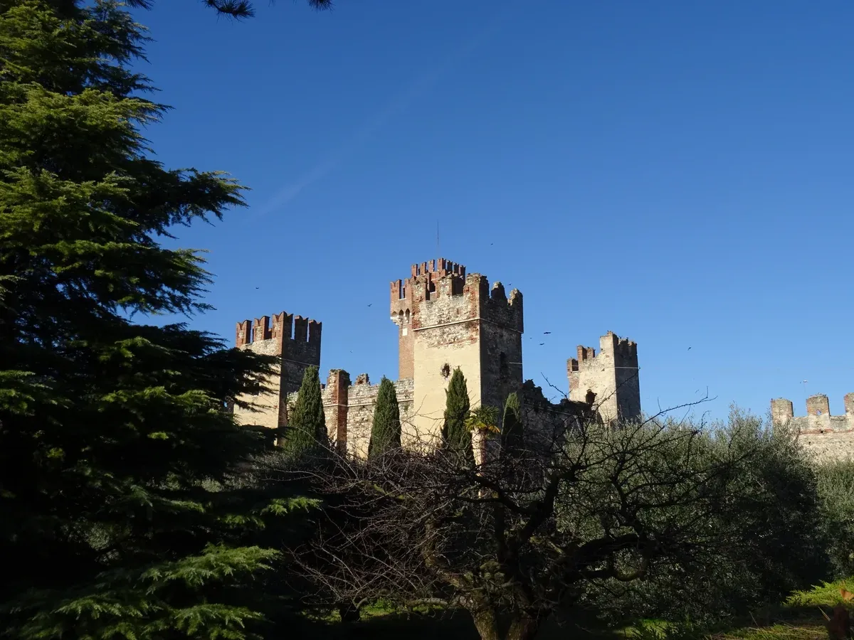The towers and battlements of the Scaliger castle of Lazise seen through trees, Lake Garda, Italy