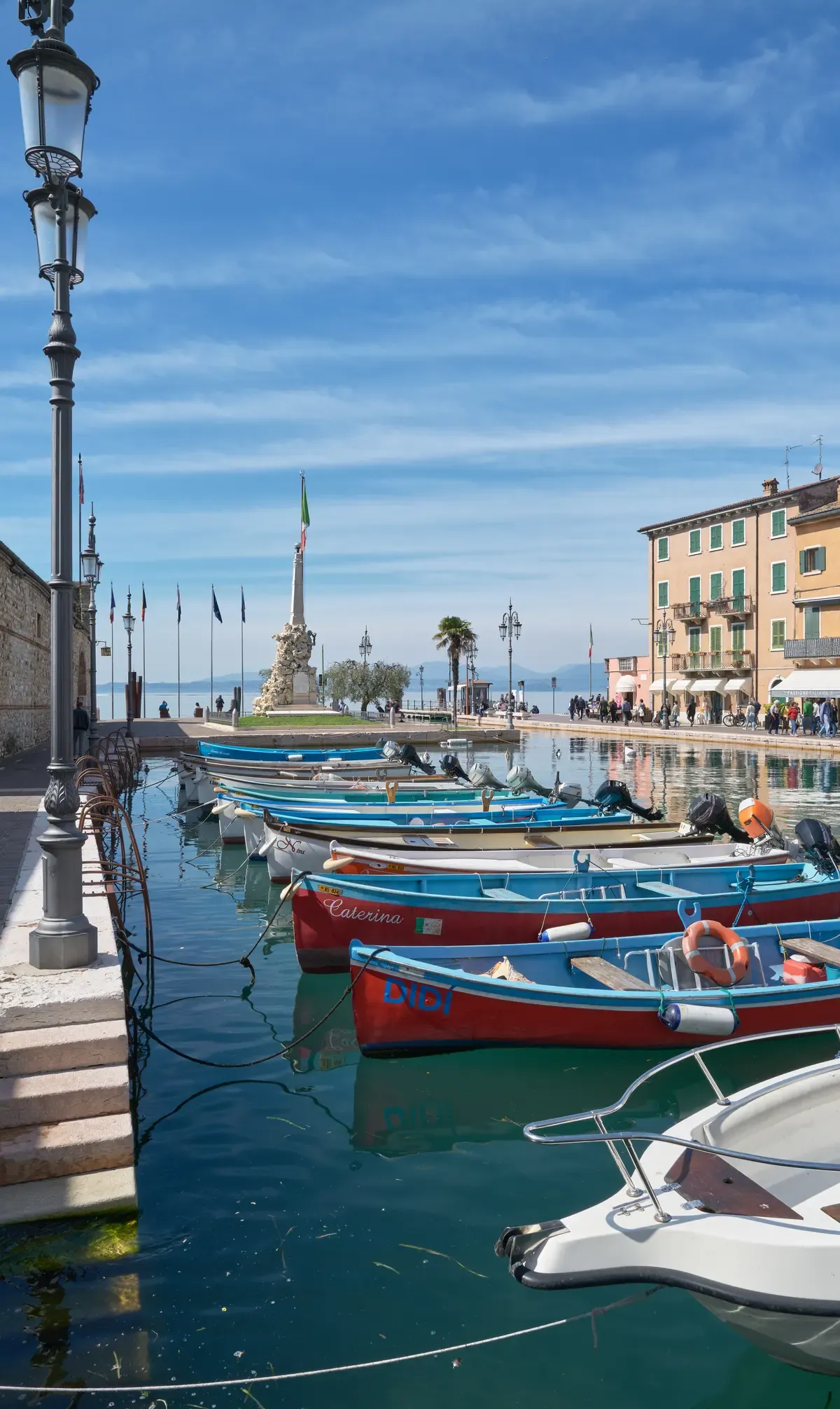 Red and blue rowing boats lined up in the old harbor of Lazise