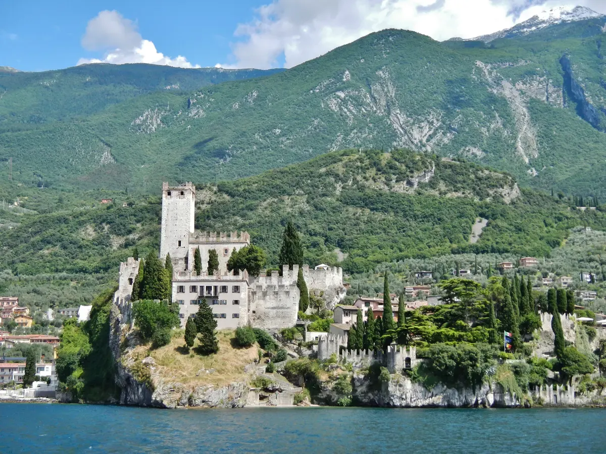 The Castello Scaligero di Malcesine on its rock seen from Lake Garda with Monte Baldo behind, Italy