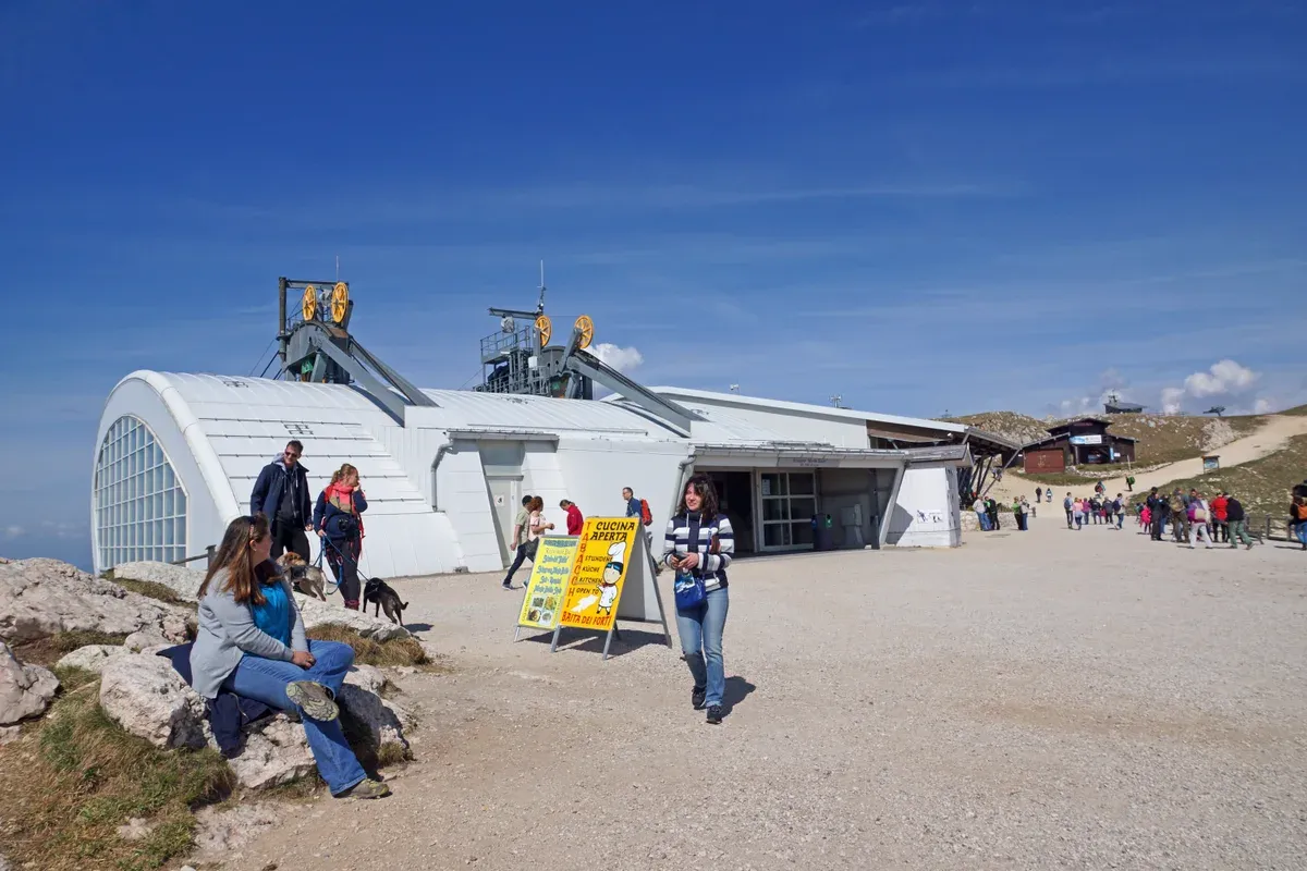 The Monte Baldo cable car top station at Tratto Spino with walkers on the ridge above Lake Garda, Italy