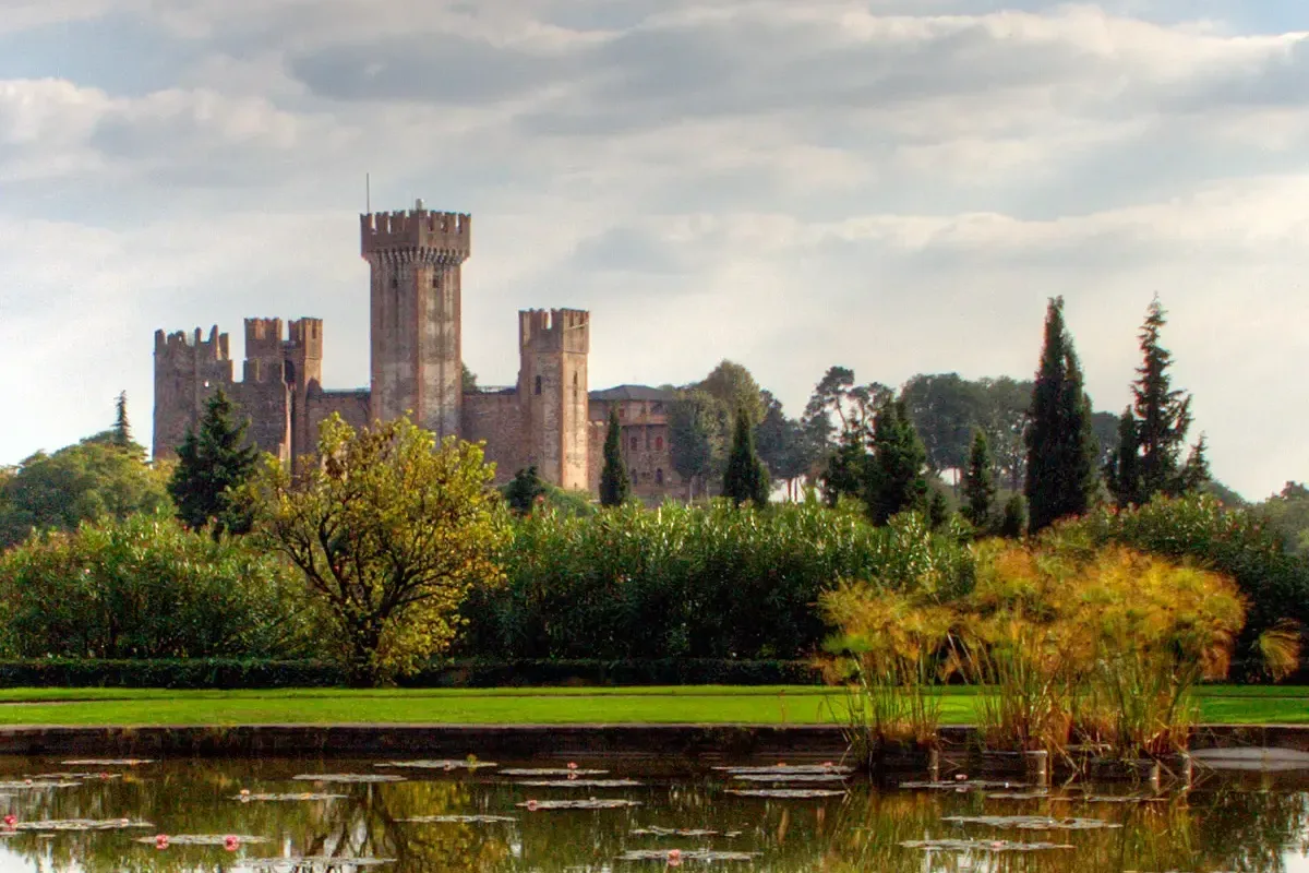 The Scaliger castle of Valeggio seen across a water-lily pond in Parco Giardino Sigurtà near Lake Garda, Italy
