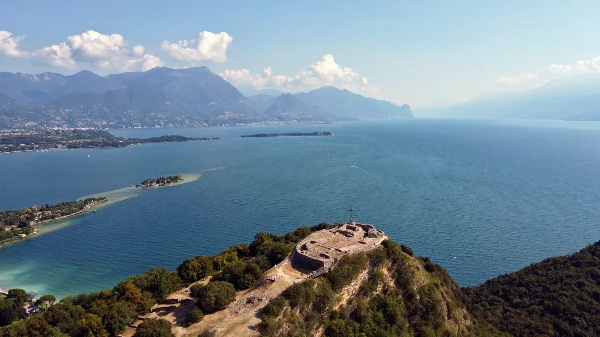 The Rocca di Manerba headland above the gulf with San Biagio island, seen near Isola del Garda, Lake Garda, Italy