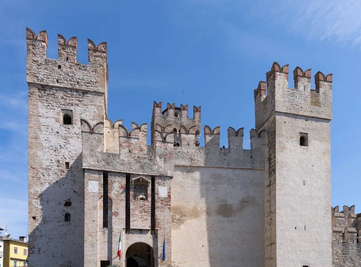 The arched entrance gate and crenellated towers of the Scaligero Castle in Sirmione, Lake Garda, Italy