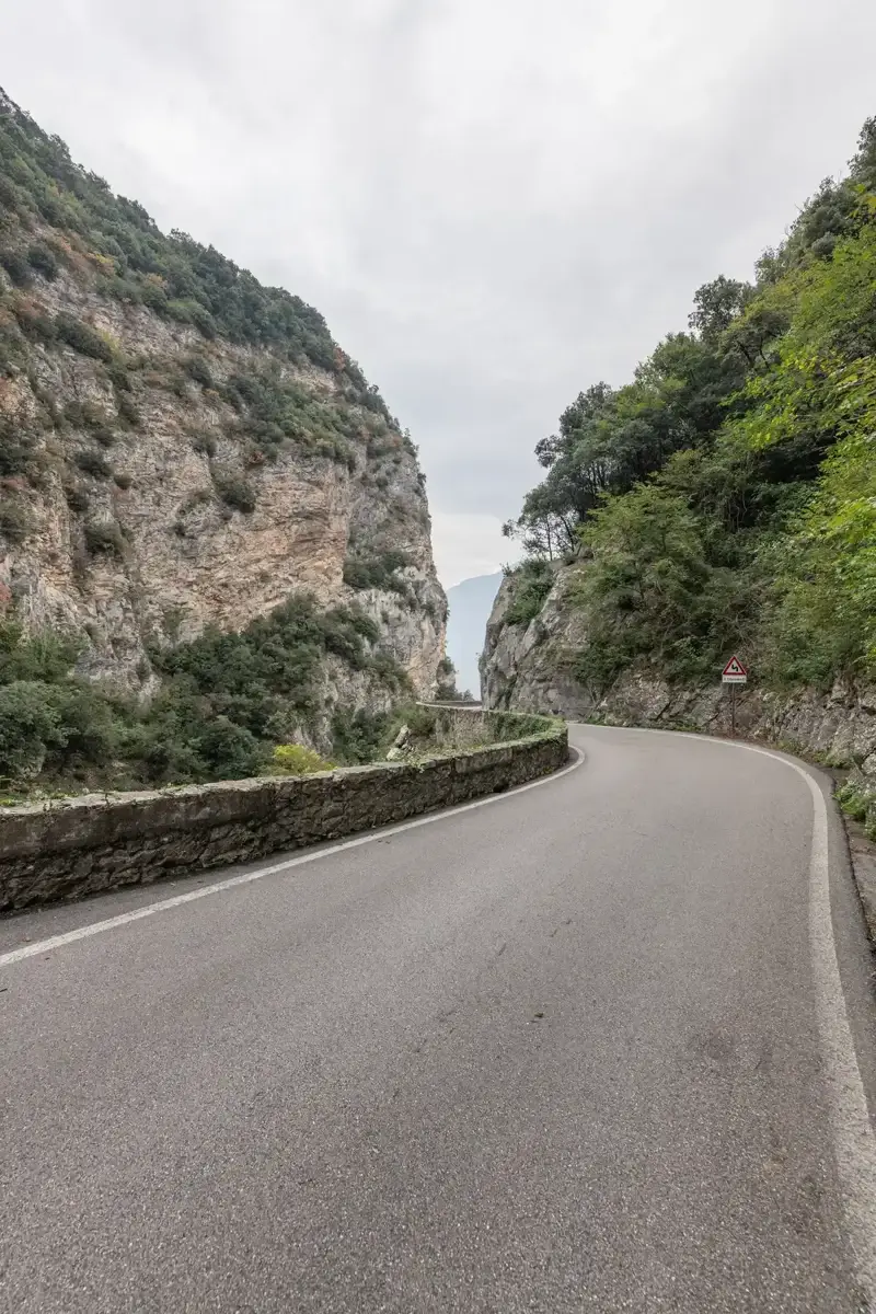 The Strada della Forra road curving between limestone walls above Lake Garda at Tremosine, Italy
