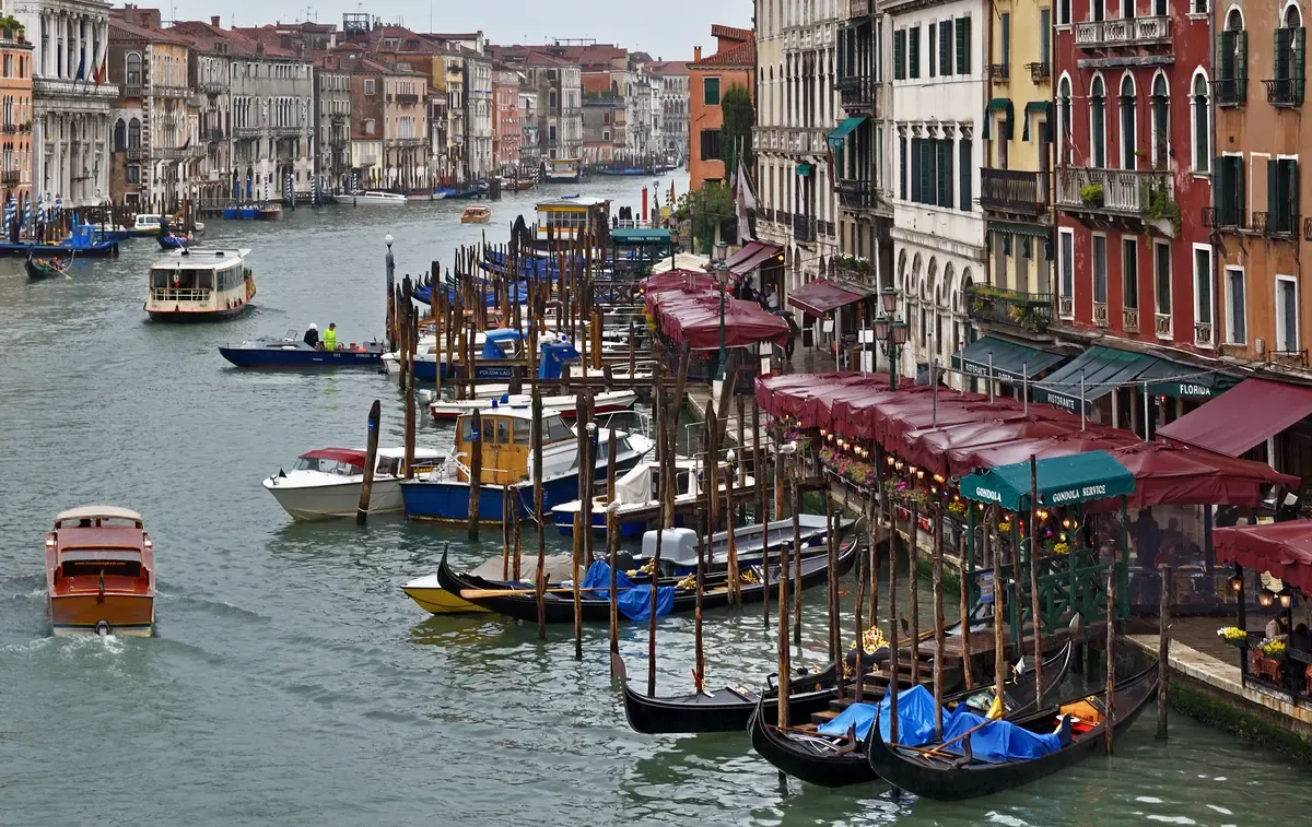 Boats and gondolas on the Grand Canal near the Rialto Bridge in Venice, a day trip from Lake Garda, Italy
