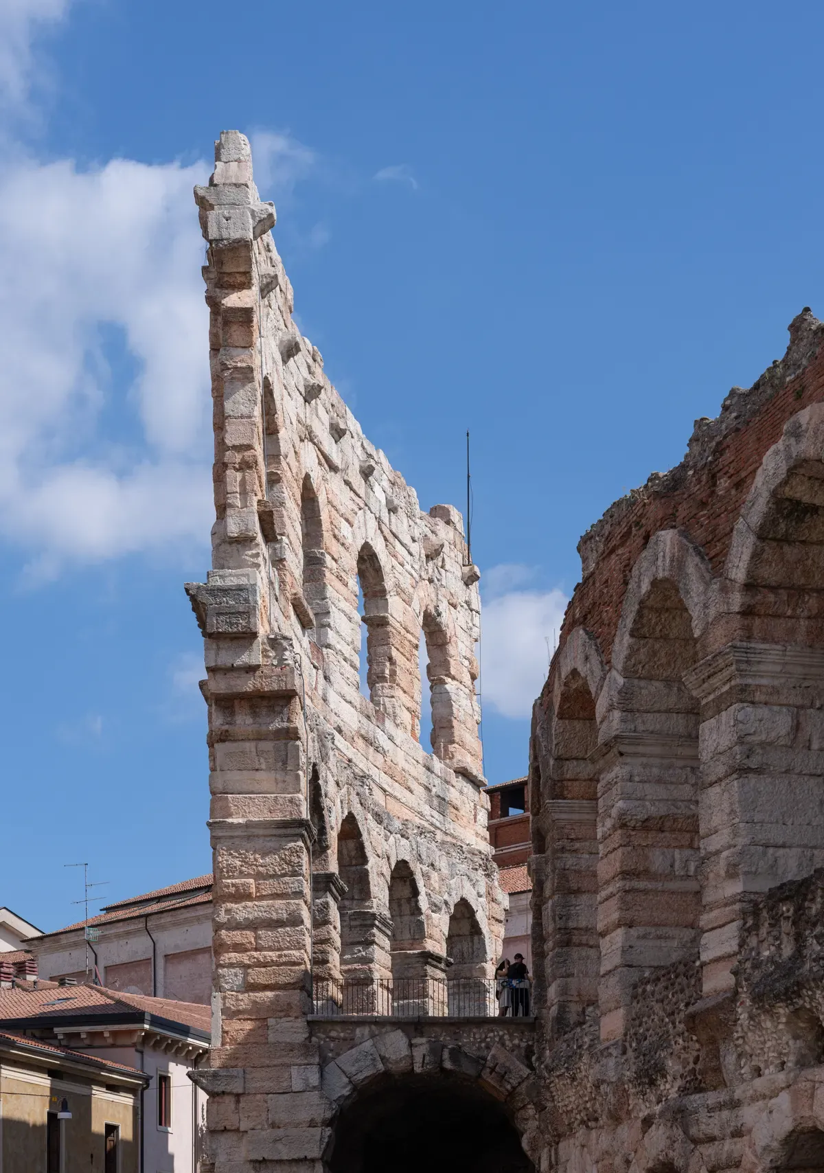 Arches of the surviving outer wall of the Verona Arena against a blue sky