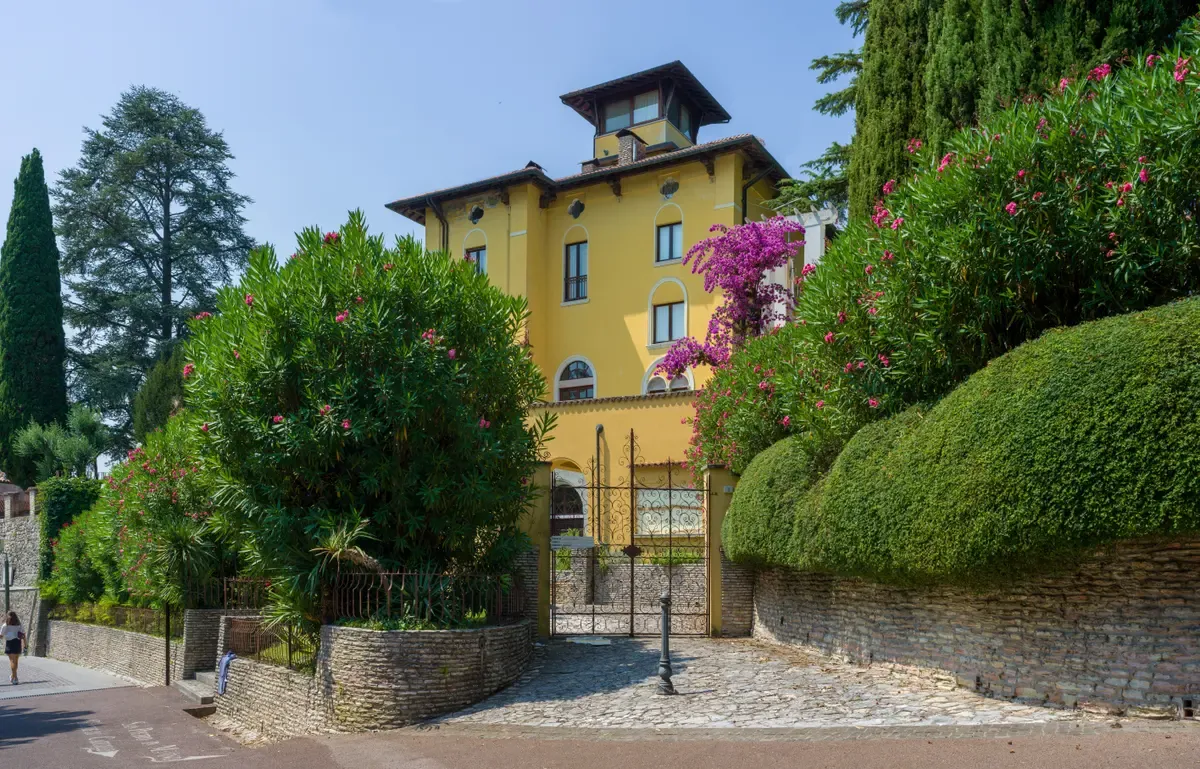 The yellow Villa Callas behind its gate on Via Catullo in Sirmione, Lake Garda, Italy