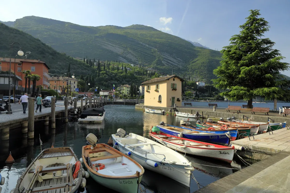 Wooden boats in the old harbour of Torbole on Lungolago Conca d'Oro, Lake Garda, Italy