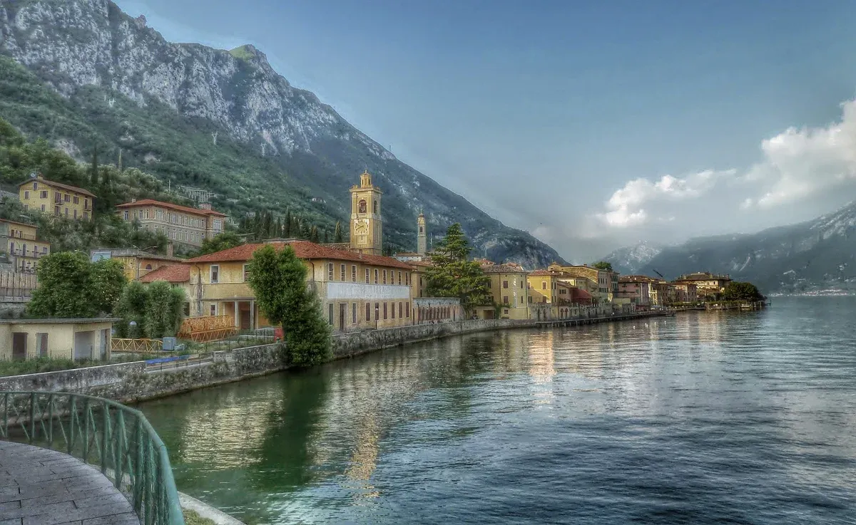 The lakefront of Gargnano with its church tower under the mountains, west shore of Lake Garda, Italy